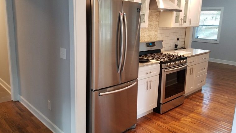 Renovated kitchen with stainless appliances and white cabinets