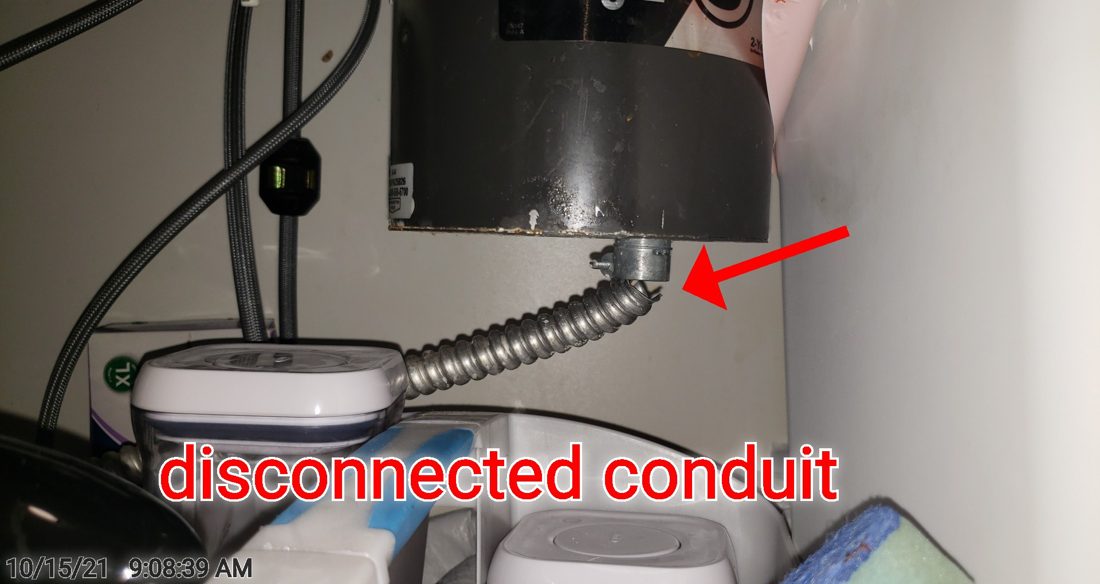 Disconnected electrical conduit and exposed wiring under the garbage disposal