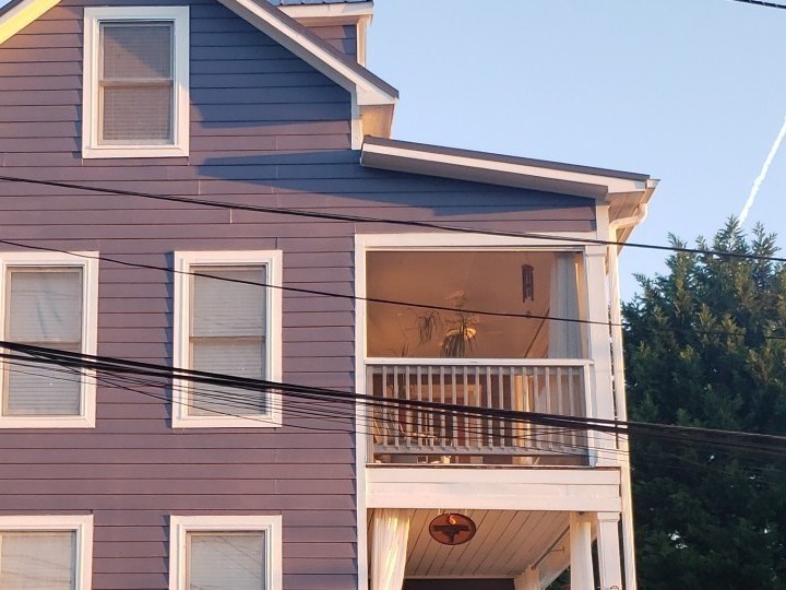 A three-story home, freshly painted blue, listed move-in ready