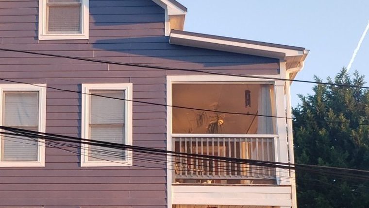 A three-story home freshly painted blue